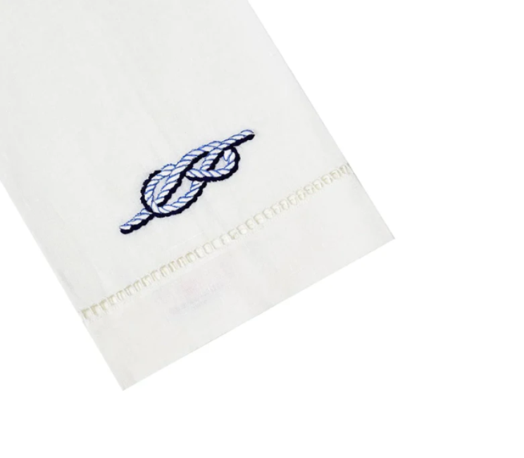 White tip towel with blue embroidered knot design on a white background