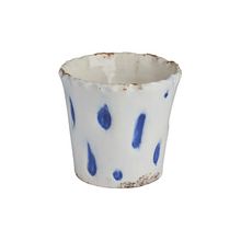 Ceramic cup with blue speckles on a white background