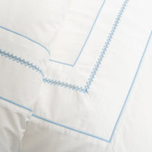 Close up of white duvet cover with blue embroidery