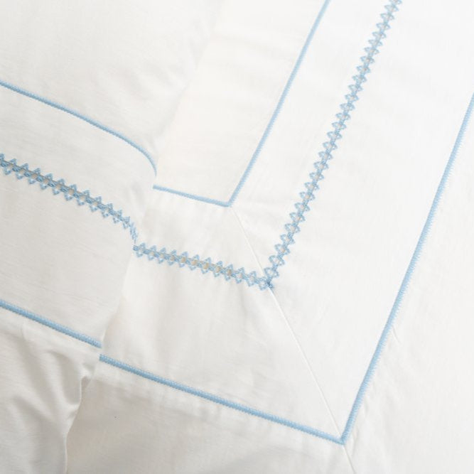 Close up of white duvet cover with blue embroidery