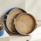 Two seagrass basket trays with blue outside on white background.