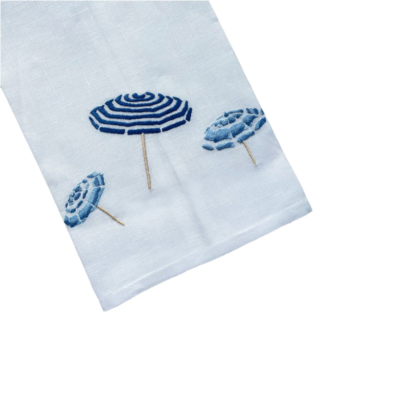 White tip towel with blue embroidered beach umbrella designs on a white background