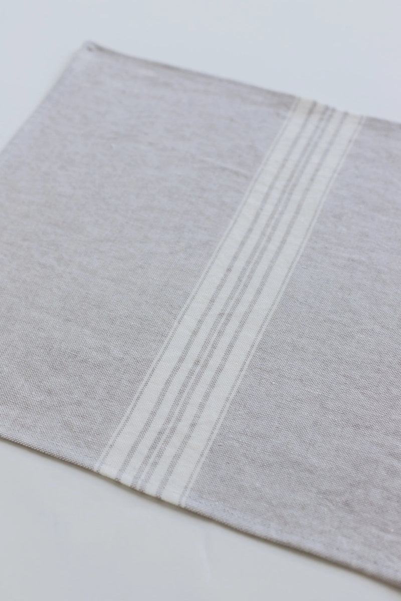 Gray linen placemat with white stripes on a light gray background
